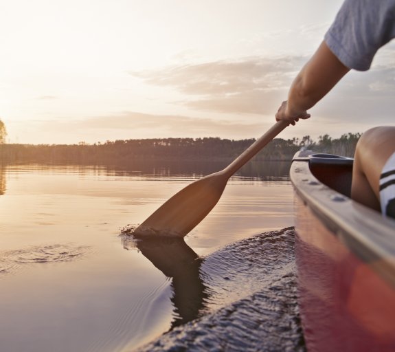 Woman canoeing at sunset in Manitoba